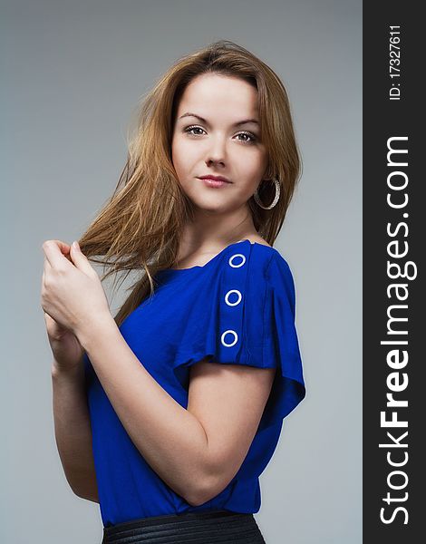 Beautiful woman in blue top with long brown hair - isolated on gray. Beautiful woman in blue top with long brown hair - isolated on gray