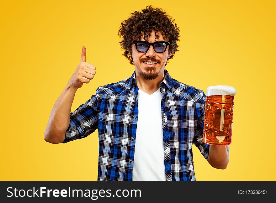 St Patrick Day. Young Oktoberfest Man Serving Big Beer Mug With Drink Isolated On Yellow Background. Guy Showing Thumbs