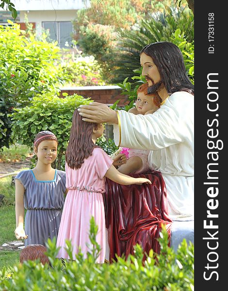 Christ sculpture show feeling love with child in garden. Christ sculpture show feeling love with child in garden