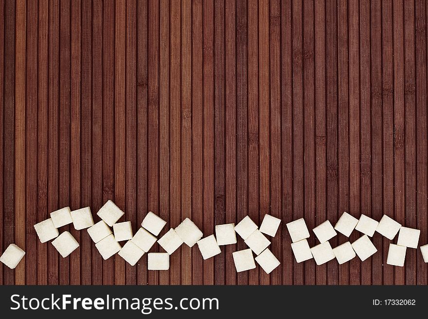 White sugar on wooden background