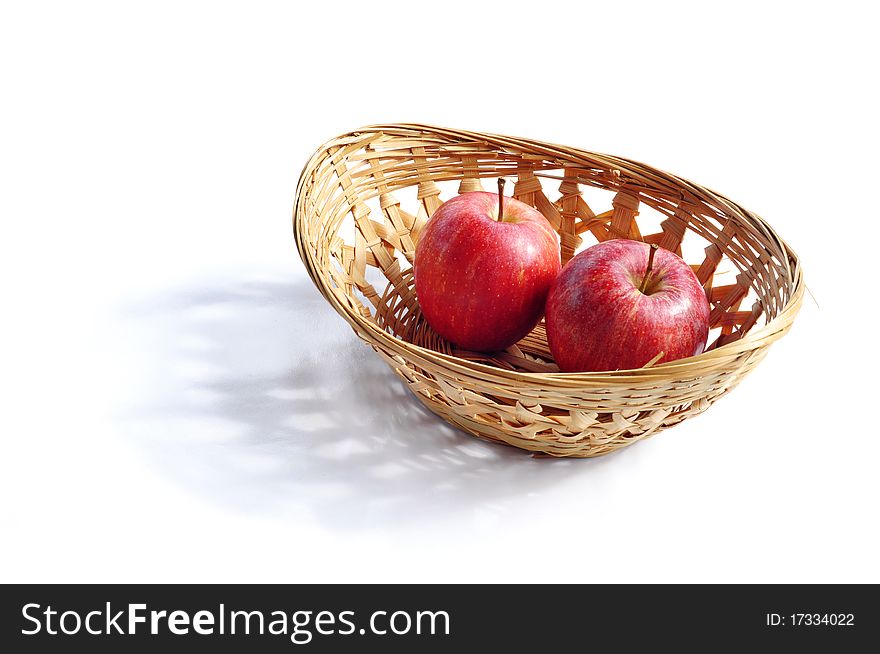 Red apples in the basket isolated on white background