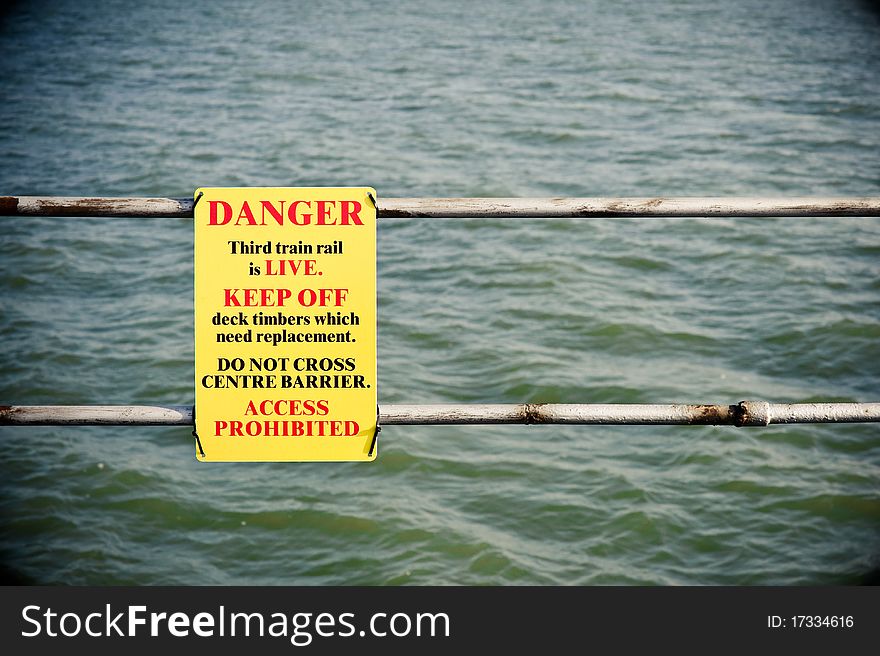 Electric shock danger sign on fencing over water