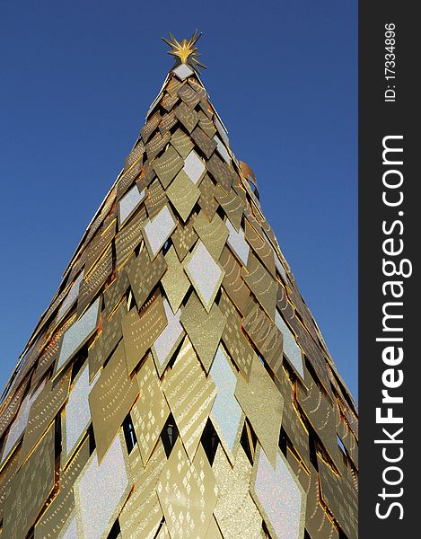 Golden tower made of rhombus materials with blue sky as background