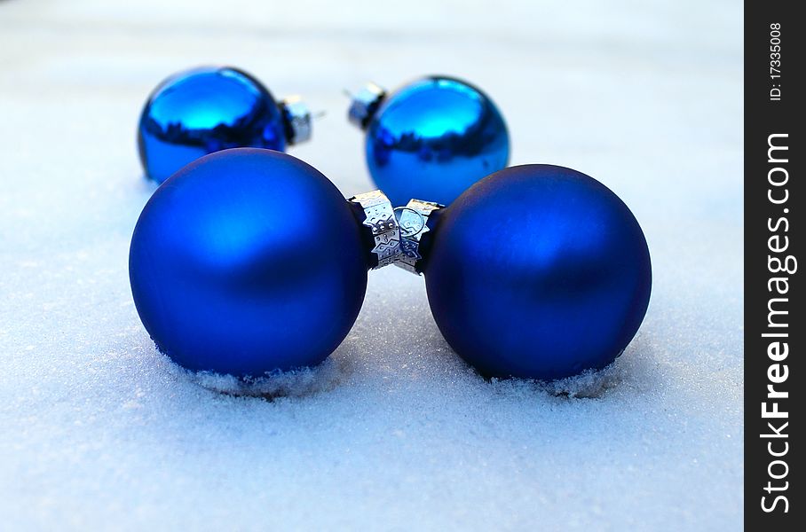 Christmas-balls lie on the snow, blue matt
