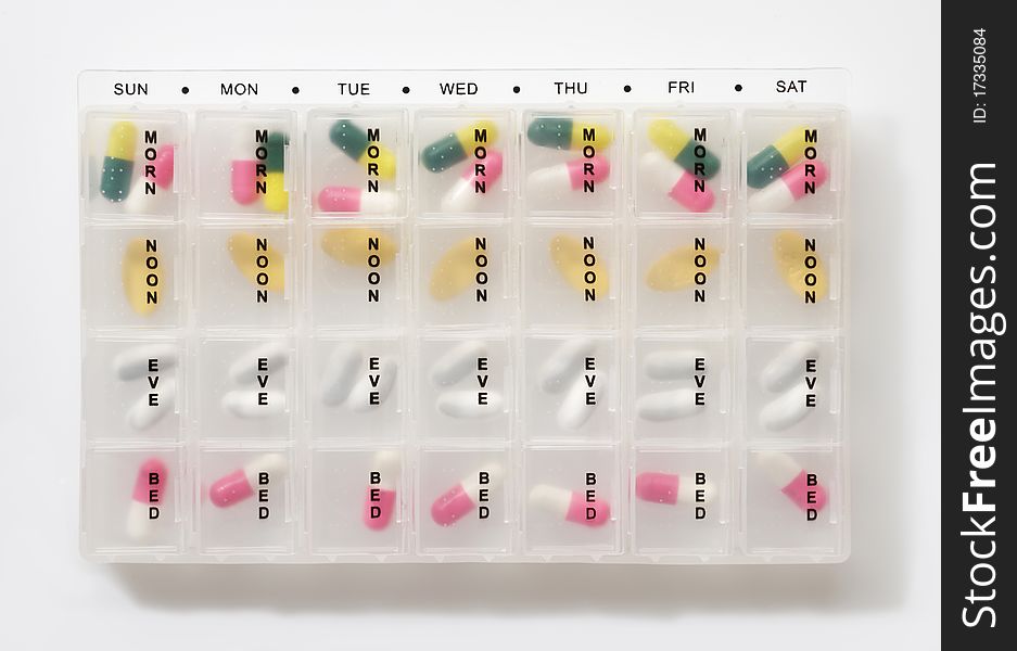 Different types of pills in a weekly dosage container. Different types of pills in a weekly dosage container