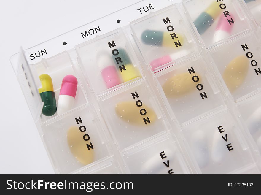 Different types of pills in a weekly dosage container. Different types of pills in a weekly dosage container