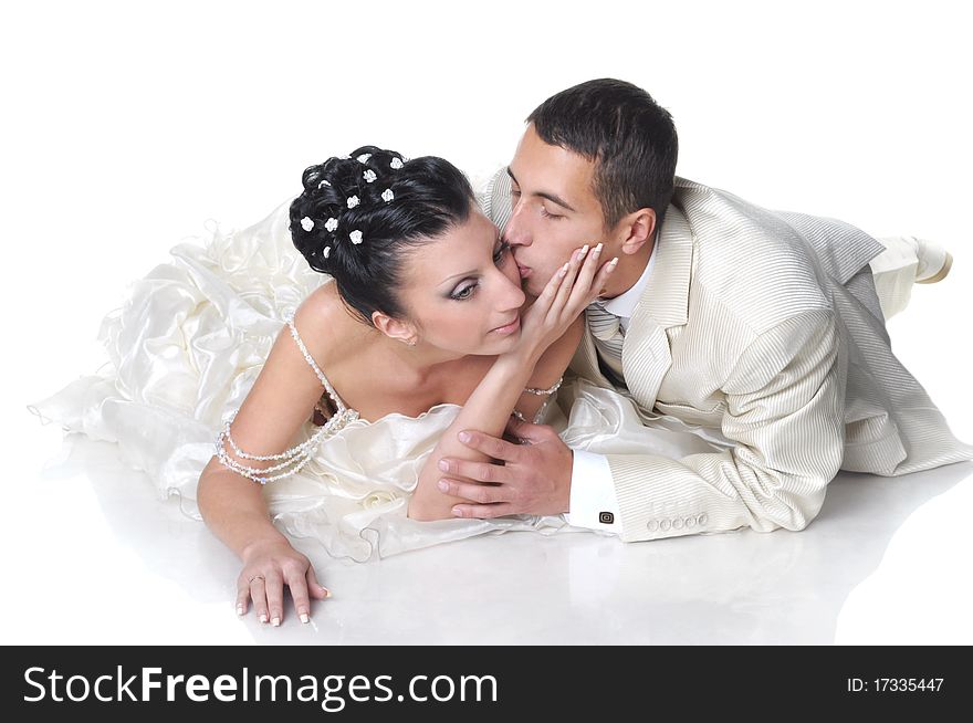 Isolated on white groom is kissing his bride wearing in wedding dress. Isolated on white groom is kissing his bride wearing in wedding dress