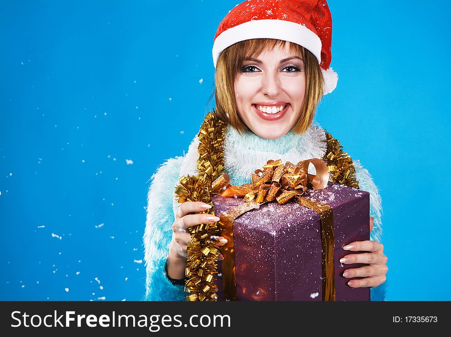 Festive girl with Christmas gift against blue background