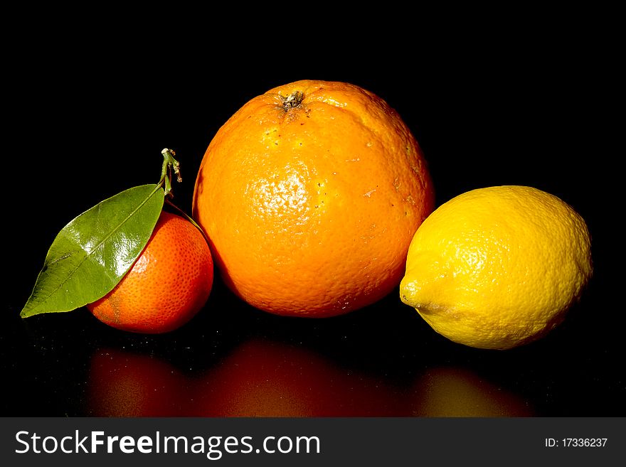 Clementine orange and lemon on black background. Clementine orange and lemon on black background