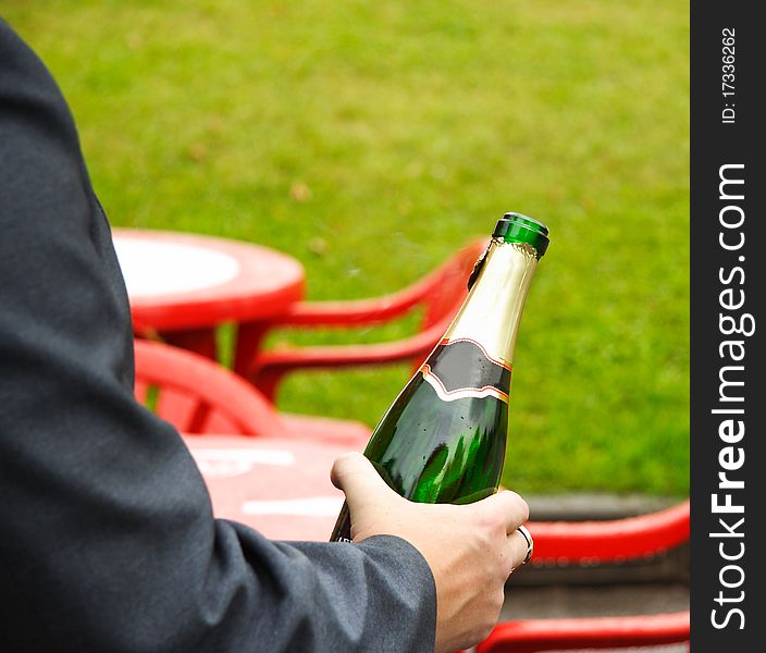The image of champagne bottle in the men's hand