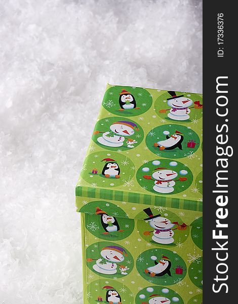 Green gift box for Christmas on a background of decorative snow.