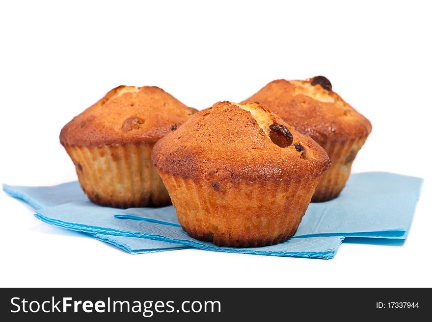 Tree muffins on blue napkin across white