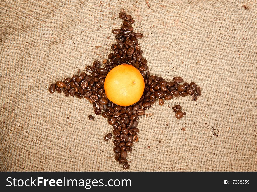 Star of fragrant fried coffee beans with the tangerine in the center. Star of fragrant fried coffee beans with the tangerine in the center