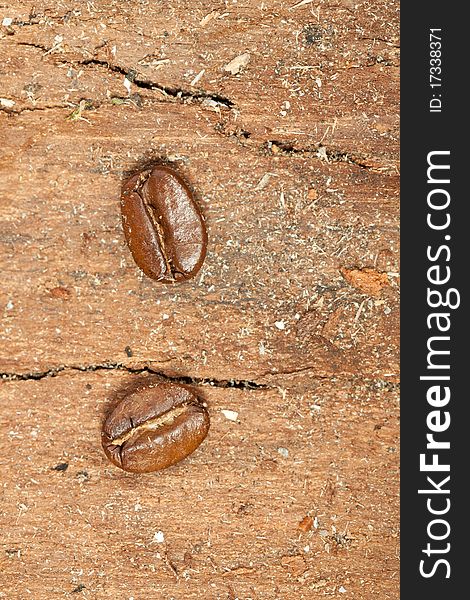 Tow close-up fragrant fried coffee beans on the wooden desk. Tow close-up fragrant fried coffee beans on the wooden desk