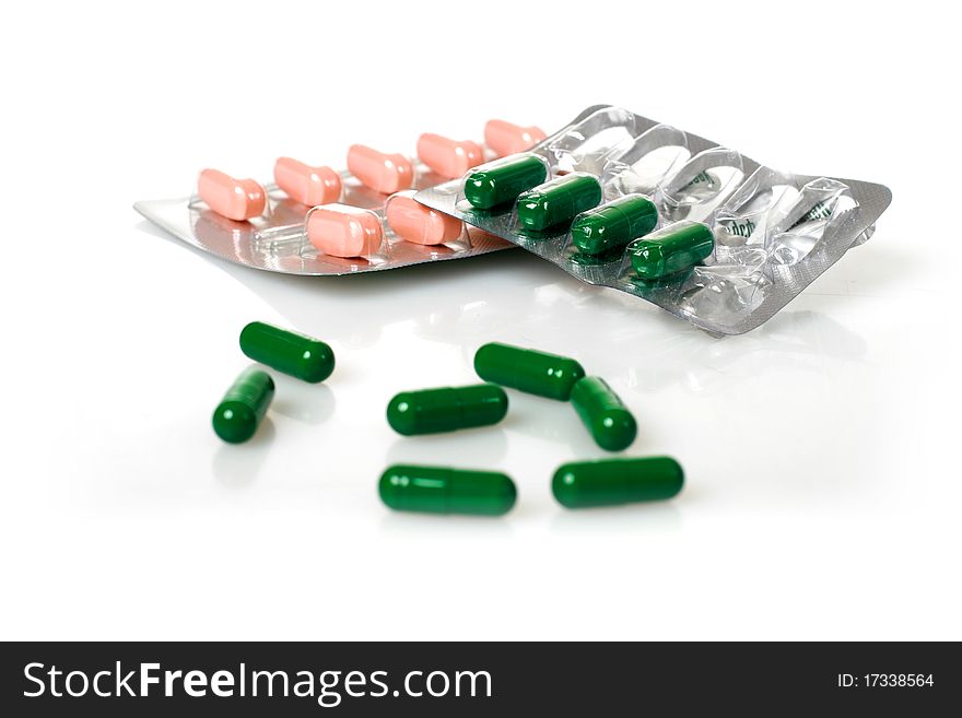 Green and pink pills isolated over white background. Green and pink pills isolated over white background.