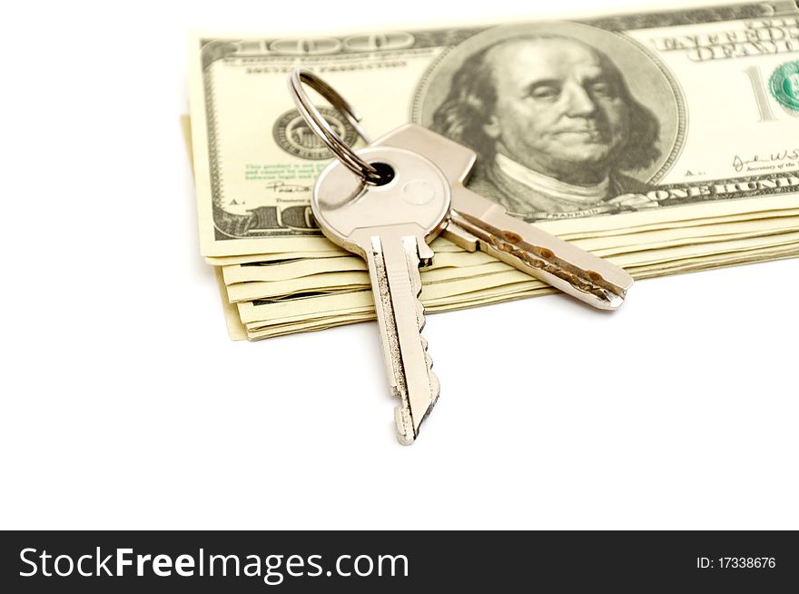 Keys and stack of dollars isolated on a white background