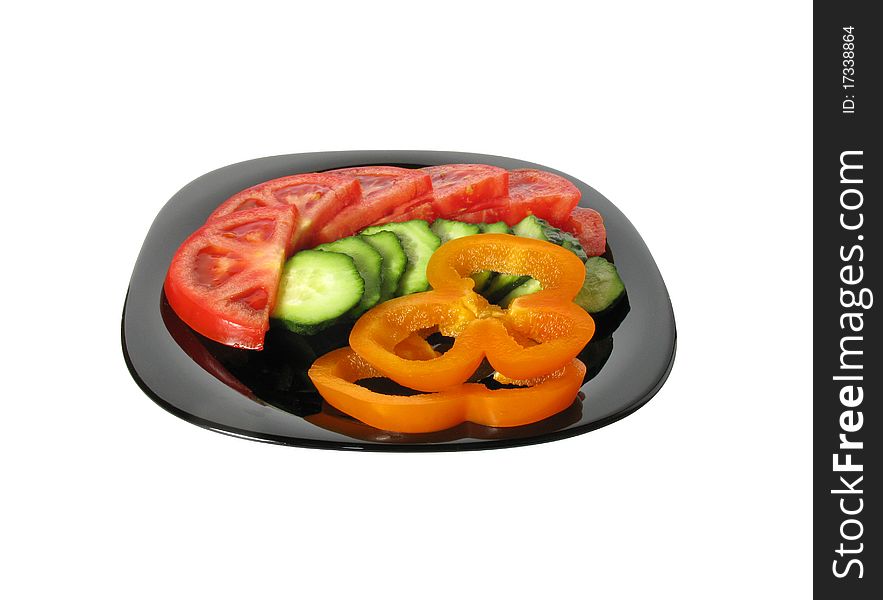 Vegetable salad on a black dish isolated on white background.