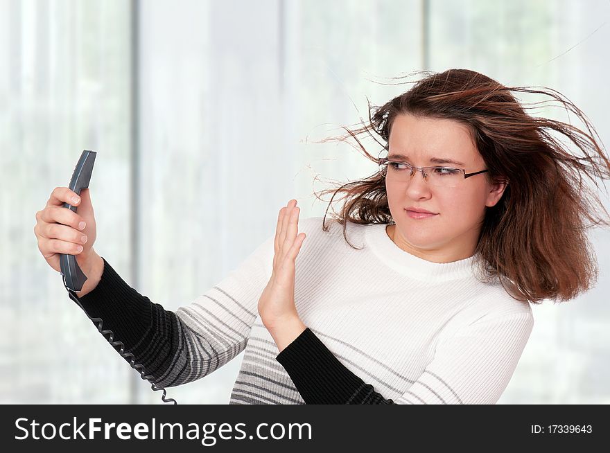 Portrait of a frightened woman with handset at her office