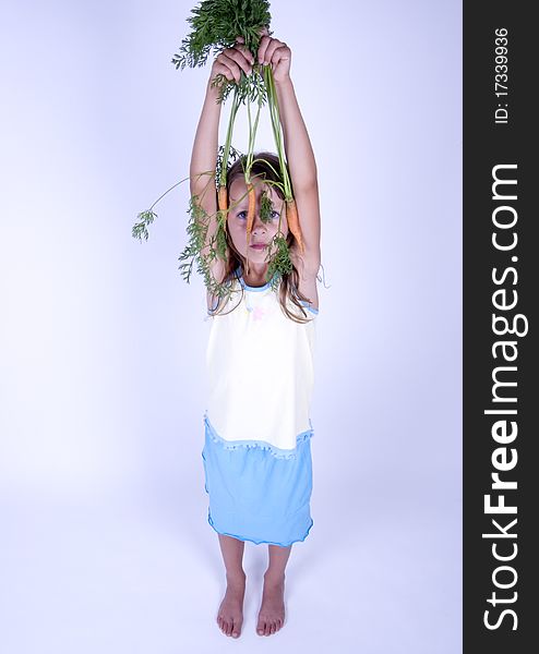 A little girl holding in her hand a beautiful carrots. A little girl holding in her hand a beautiful carrots