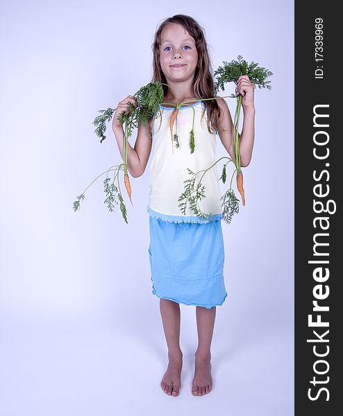 A little girl holding in her hand a beautiful carrots. A little girl holding in her hand a beautiful carrots