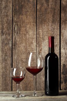 Glass And Bottle With Delicious Red Wine On Table Against Wooden Background. Creative Photo. Stock Images