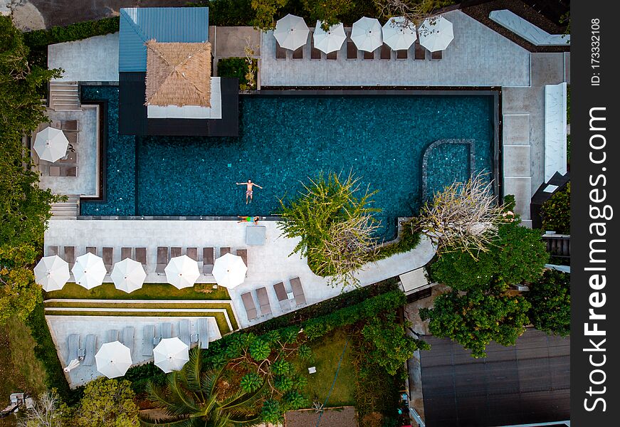 Top view swimming pool, drone view pool, couple in swimming pool during vacation