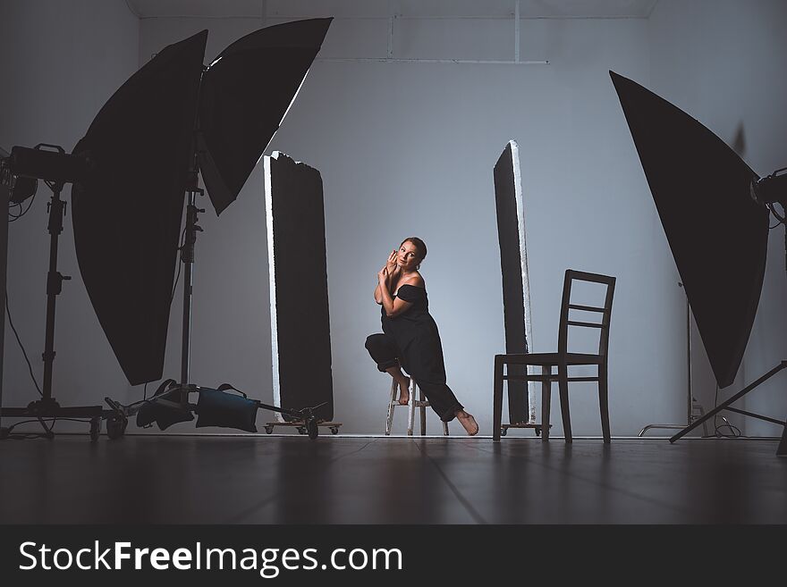 Professional photo shooting at the studio a beautiful model posing dark photo studio with professional lighting equipment, softboxes