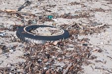 Tire And Other Litter On A Beach Royalty Free Stock Images