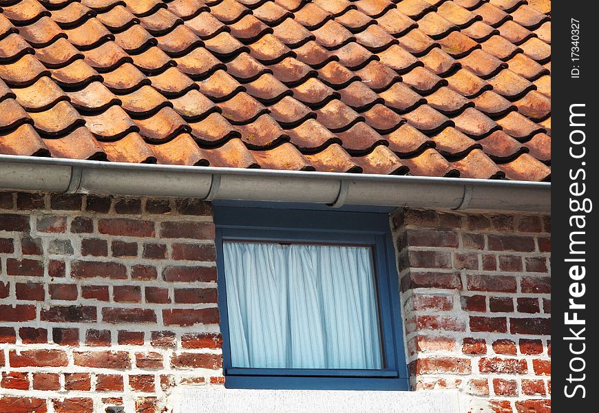 Roof and wall of a brick building with a window