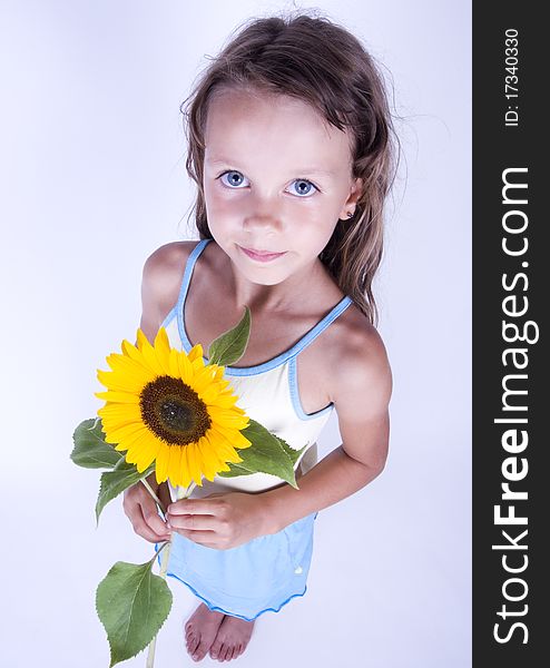 A little girl holding in her hand a beautiful sunflower