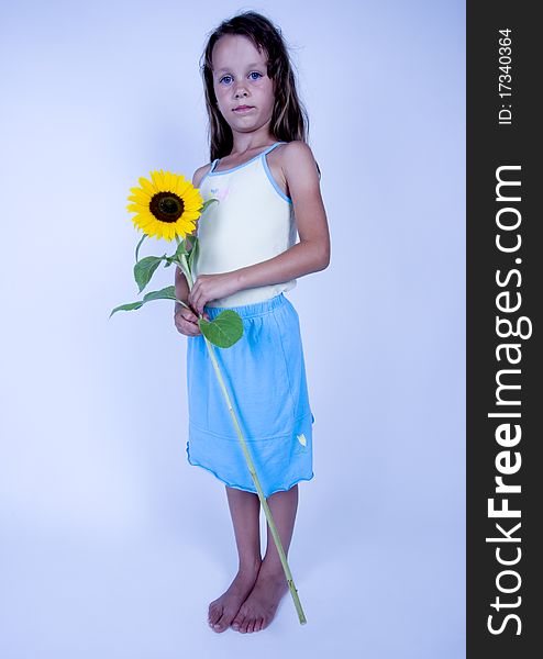 A little girl holding in her hand a beautiful sunflower