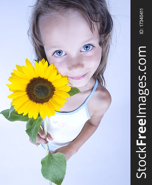 A little girl holding in her hand a beautiful sunflower