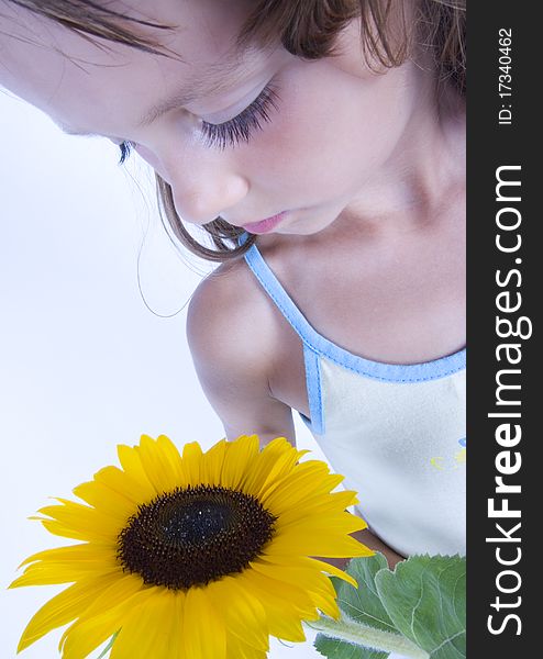 A little girl holding in her hand a beautiful sunflower. A little girl holding in her hand a beautiful sunflower