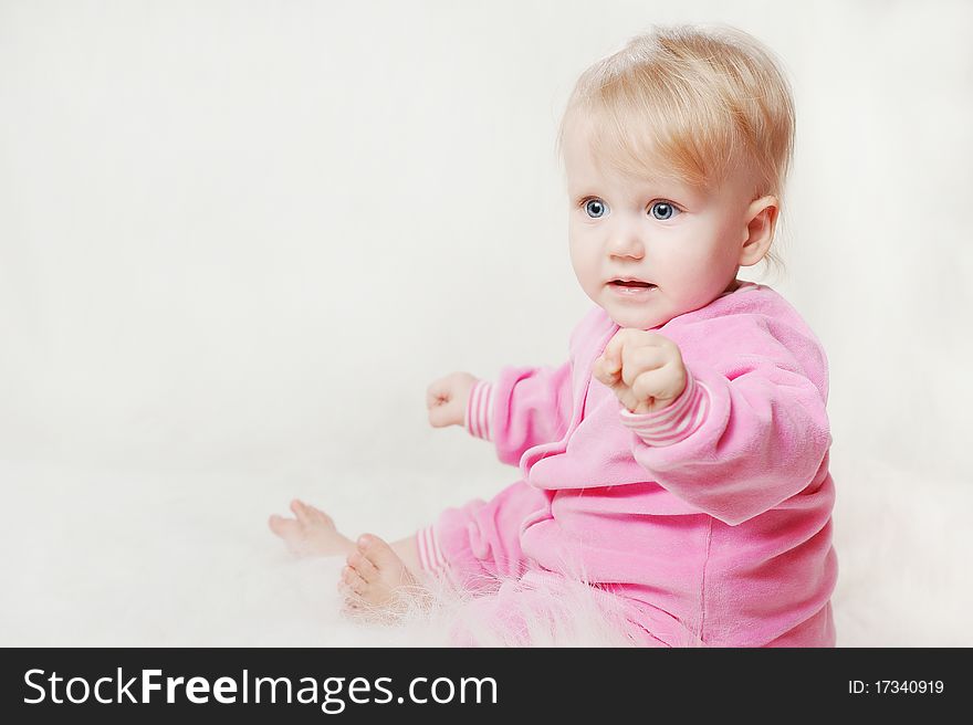 Portrait of a little baby wearing a pink snow suit on a soft blanket 
Image ID: 66482407