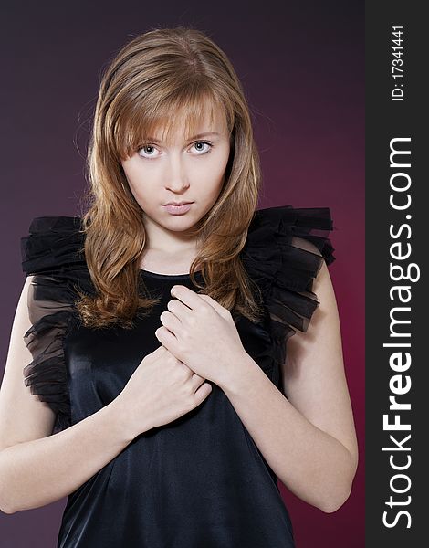 Portrait of a beautiful sensuality woman in black dress posing over red background