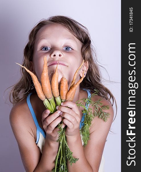 A little girl holding in her hand a beautiful carrots. A little girl holding in her hand a beautiful carrots