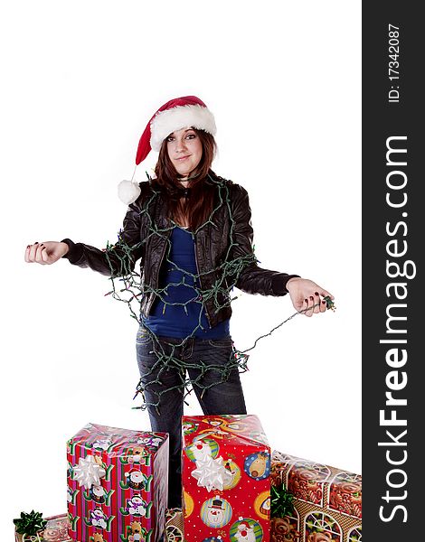A woman all tied up in a bunch of Christmas lights by her presents with a frustrated expression on her face. A woman all tied up in a bunch of Christmas lights by her presents with a frustrated expression on her face.