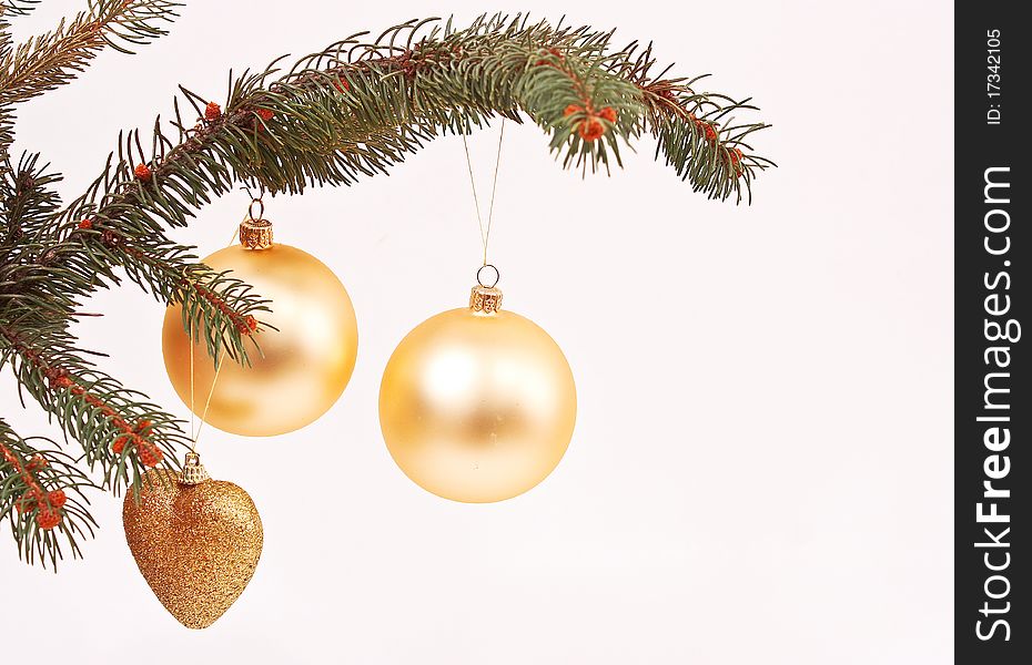 Golden globes and Christmas decorations on the tree branch