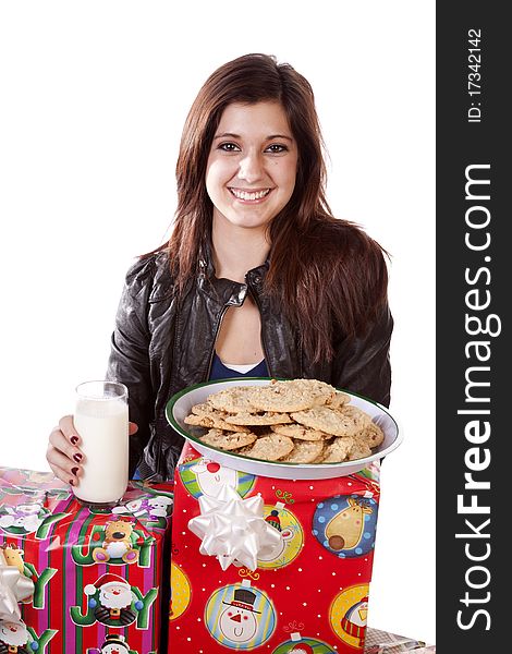 A woman sitting by her Christmas presents and getting ready to put out some milk and cookies for Santa. A woman sitting by her Christmas presents and getting ready to put out some milk and cookies for Santa.