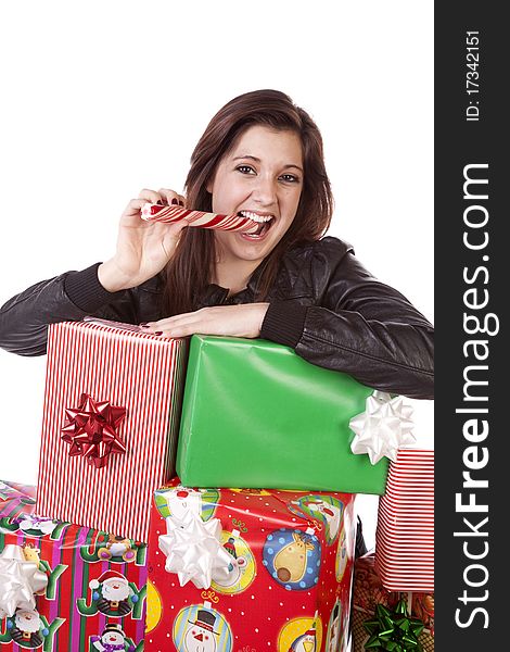 A woman leaning on her pile of Christmas presents while she eats her peppermint stick. A woman leaning on her pile of Christmas presents while she eats her peppermint stick.