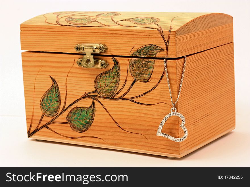 A picture of a wooden box with a heart pendant sticking out. A picture of a wooden box with a heart pendant sticking out.