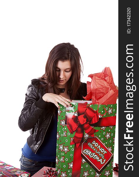 A woman taking a peek into her Christmas present with a surprised expression on her face.