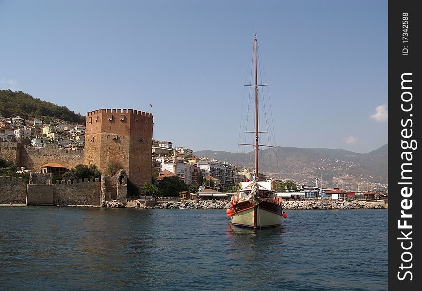 Red tower in Alanie and the yacht on the sea. Turkey