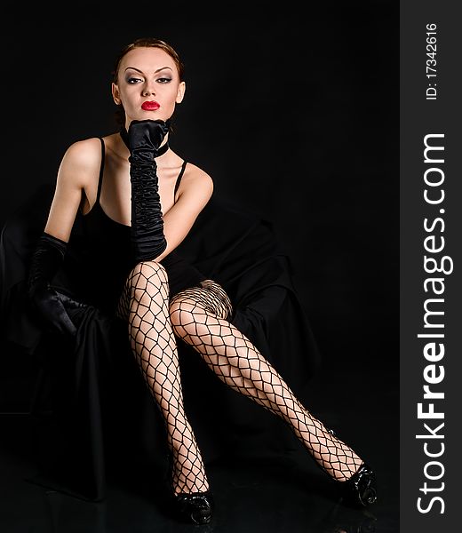 Fatale woman with ruby red lips and black openwork stockings