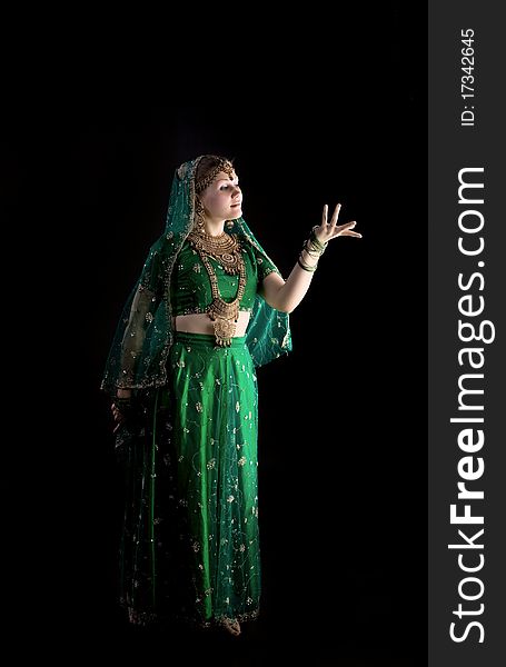 Young girl in green indian costume look at light