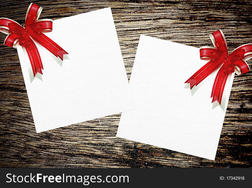 Red ribbon satin gift bow on wood background