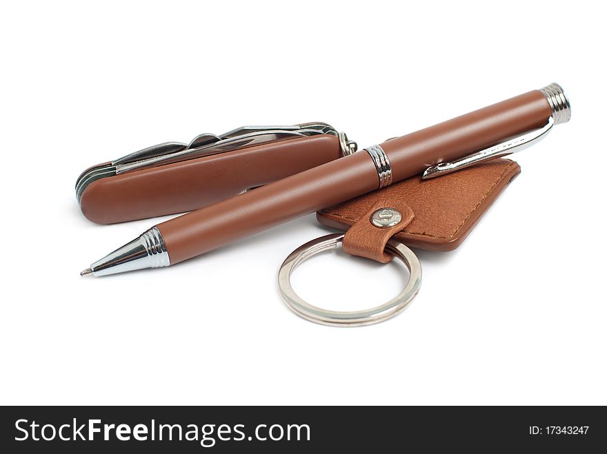 A pen, penknife and trinket, isolated on white