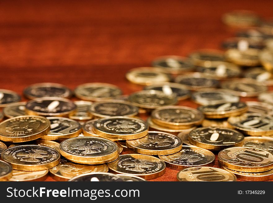 Golden coins on a wooden table close up