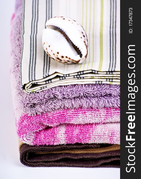 Closeup of colorful bath towels and sea shell