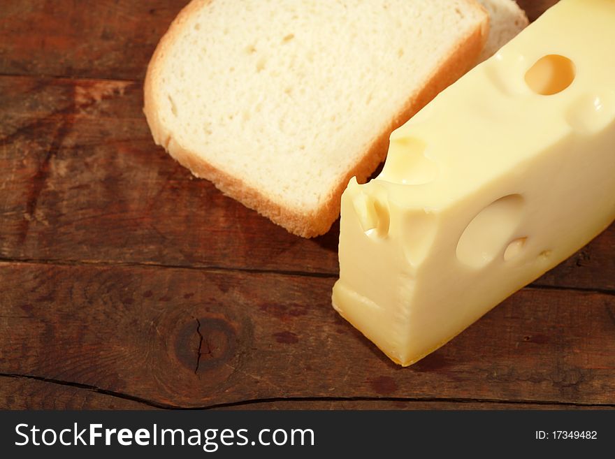 Closeup of cheese and white bread on wooden background. Closeup of cheese and white bread on wooden background